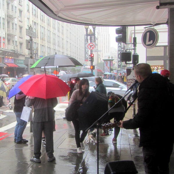 CAL SINGS IN THE RAIN AT POWELL AND O'FARRELL.