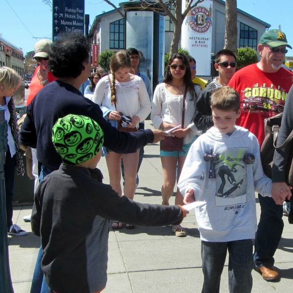 GUILLERMO AND HIS SON PABLO PASS OUT TRACTS AT WHARF.