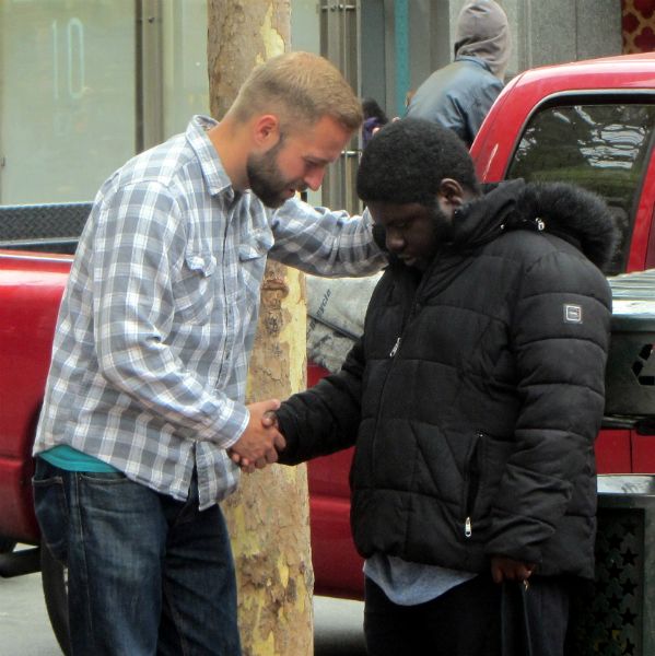 CAL PRAYS WITH MAN AT 5TH AND MARKET.