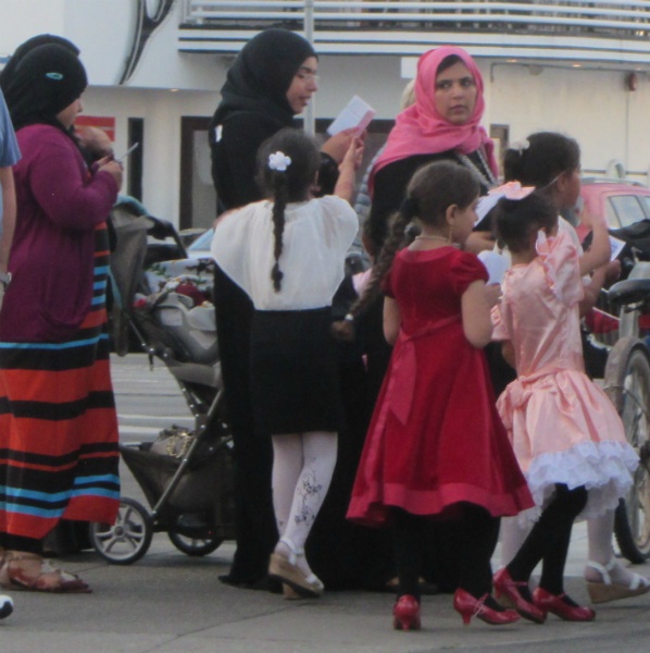 MUSLIM WOMEN AND CHILDREN READ GOSPEL TRACTS AT WHARF.