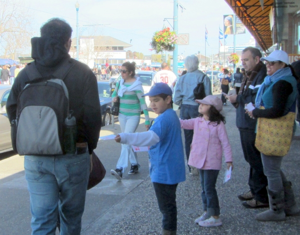 Caleb & Ruth pass out tracts at Wharf while parents Eric and Charlyne watch. 