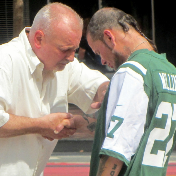 PASTOR BILL PRAYS WITH MAN AT UN PLAZA